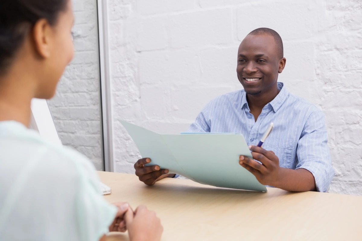 Illustrative scene: a person speaking with a professional holding a folder; no affiliation or testimonial implied.